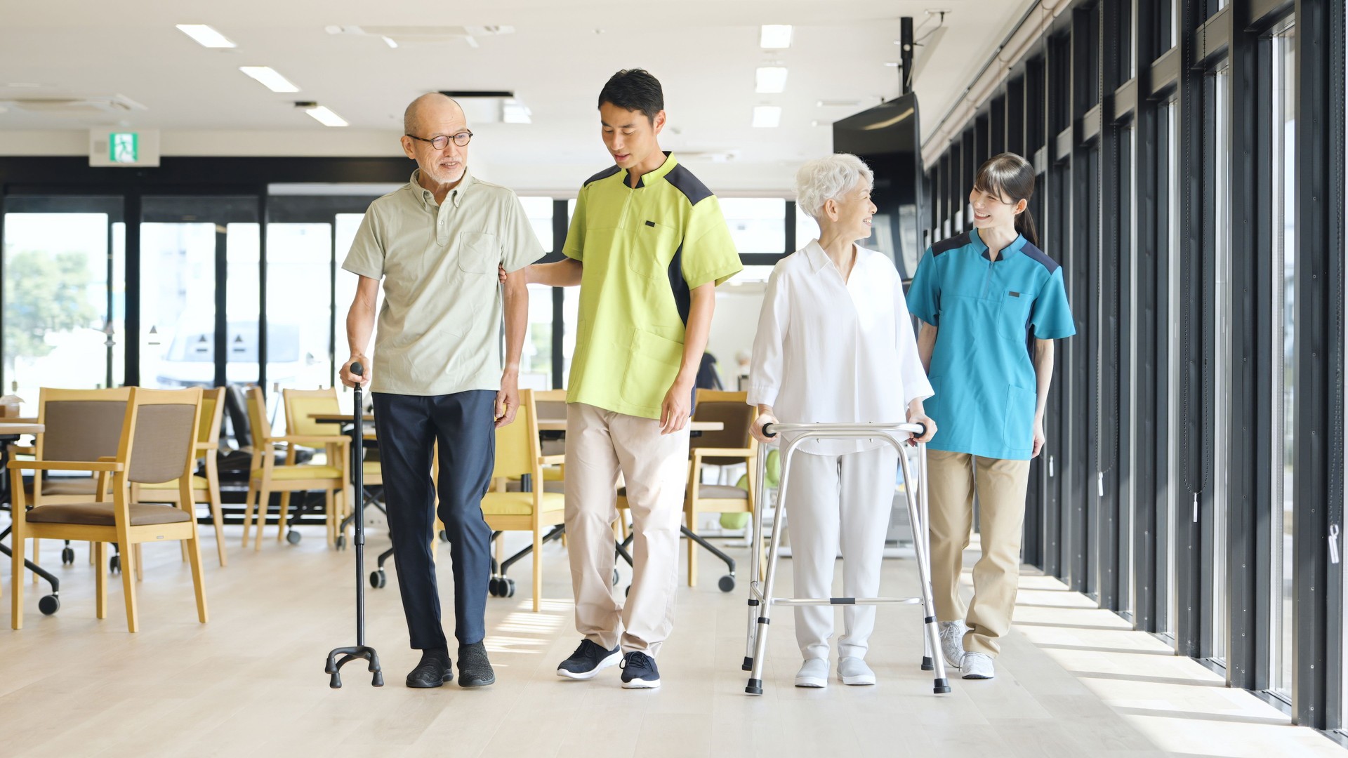 Asian caregiver supporting elderly people walking